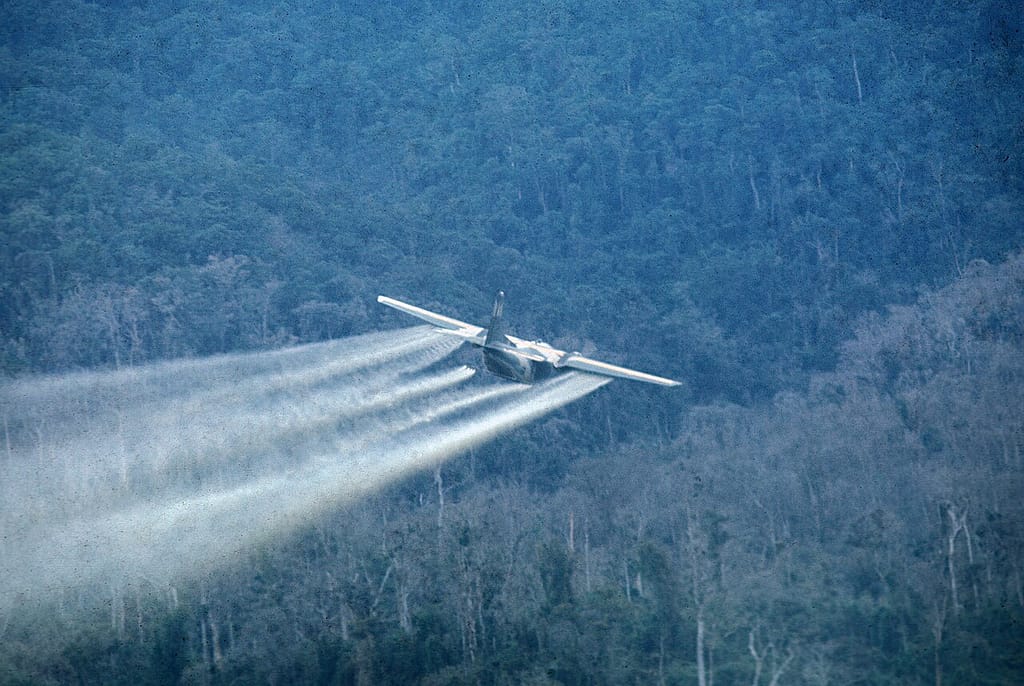 A UC-123 Provider spraying defoliant low over the Vietnamese jungle