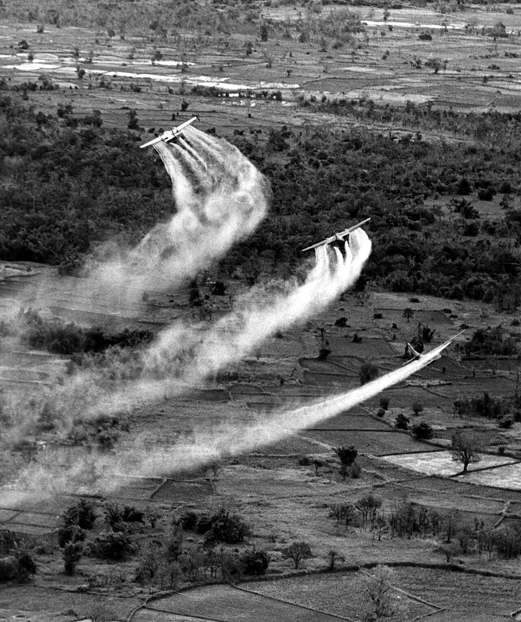 Three UC-123B Providers spraying herbicide over Vietnamese farmland