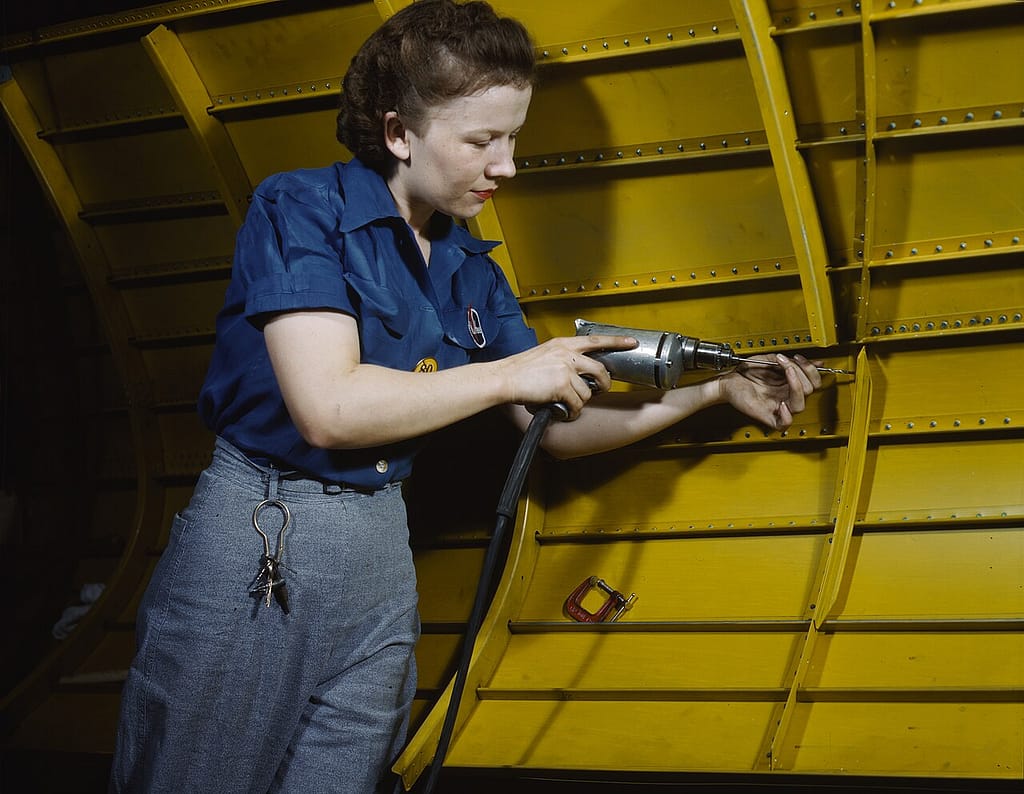 A woman operating a hand drill on a Vengeance dive bomber at Vultee Nashville