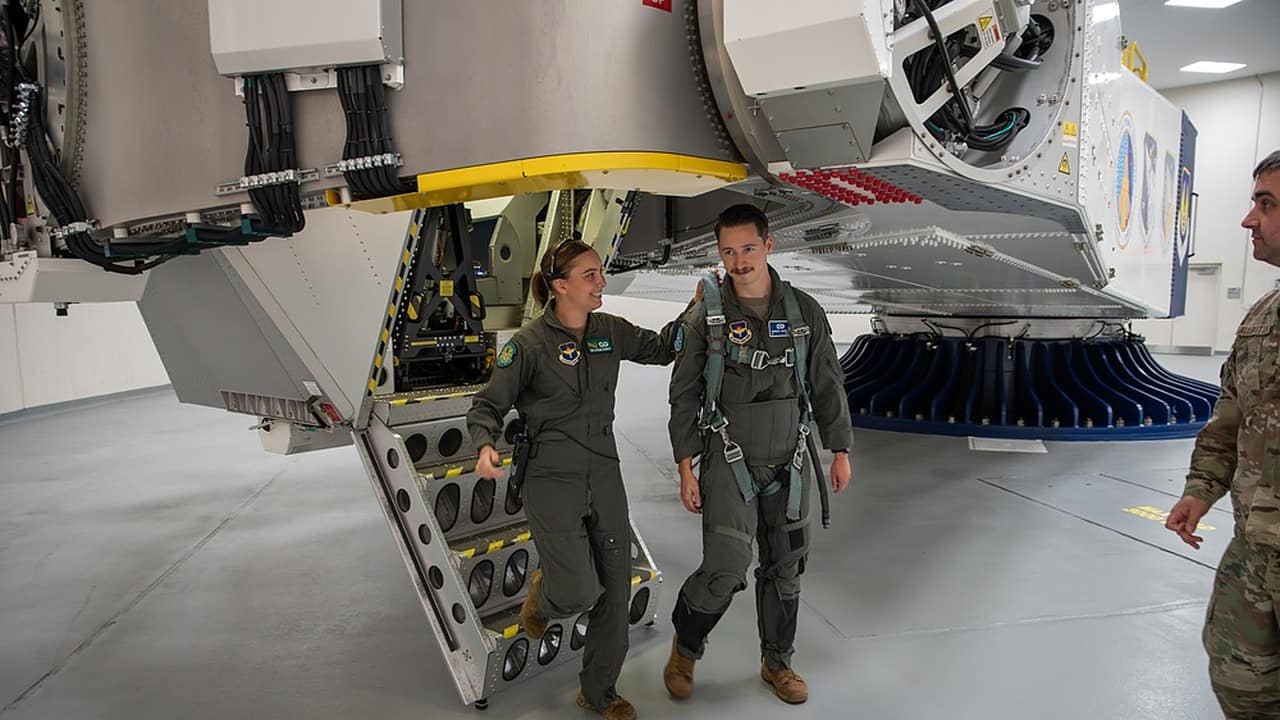 Zwei Piloten neben der menschlichen Zentrifuge, die zur Ausbildung von Flugbesatzungen für Hoch-G-Flüge verwendet wird