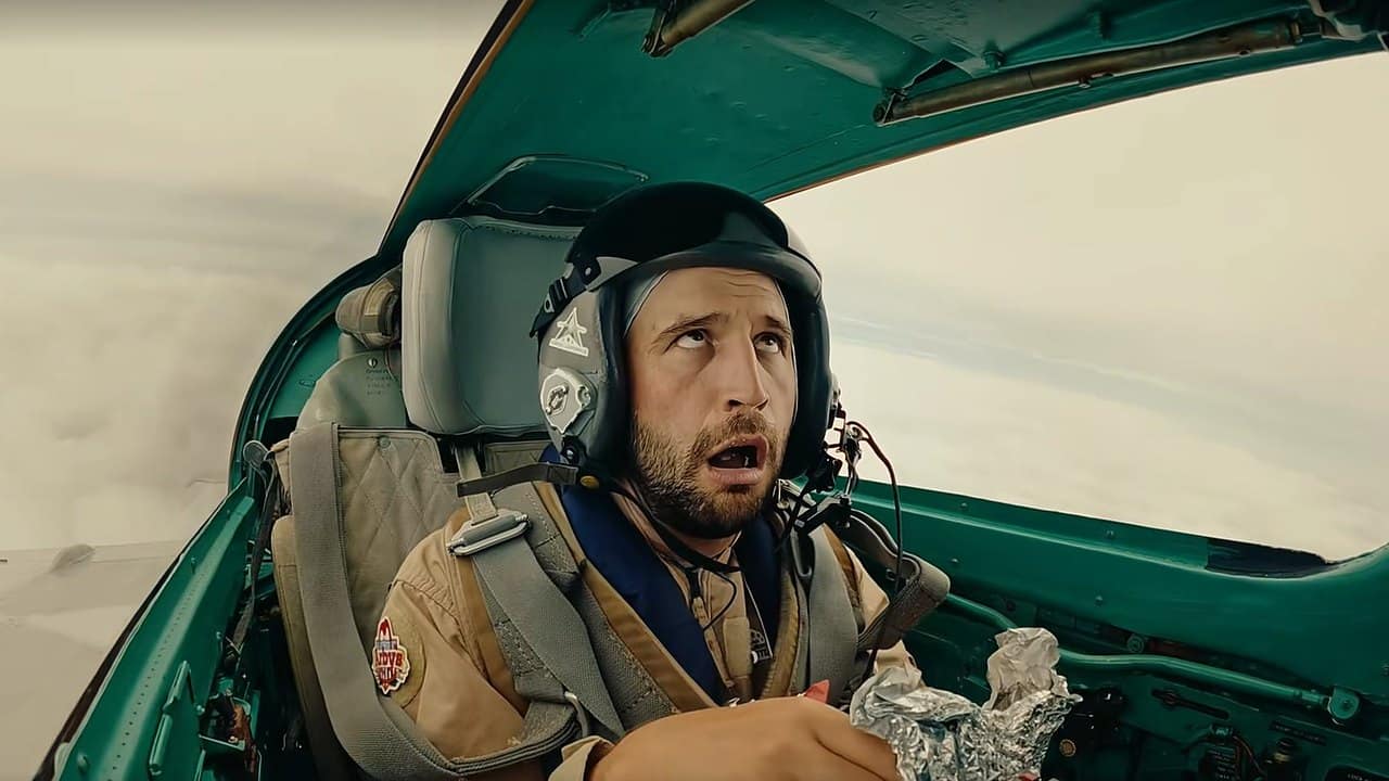 Bob Menery wide-eyed holding an Arby’s bag in the cockpit of a MiG-21 during a supersonic flight