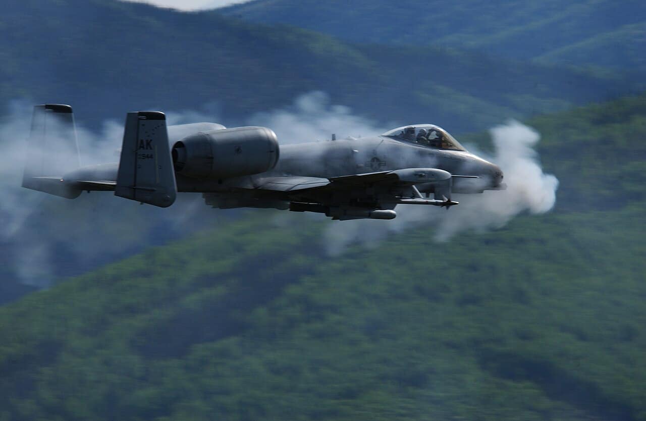 Un A-10 Thunderbolt II enveloppé de fumée de tirs lors d'une fusillade