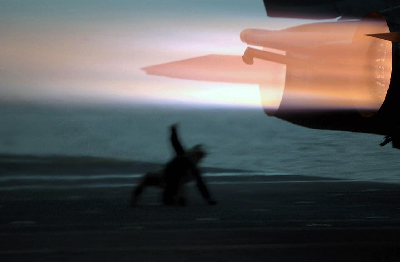 A US Navy F-14 Tomcat of VF-154 ignites its afterburners on a catapult launch