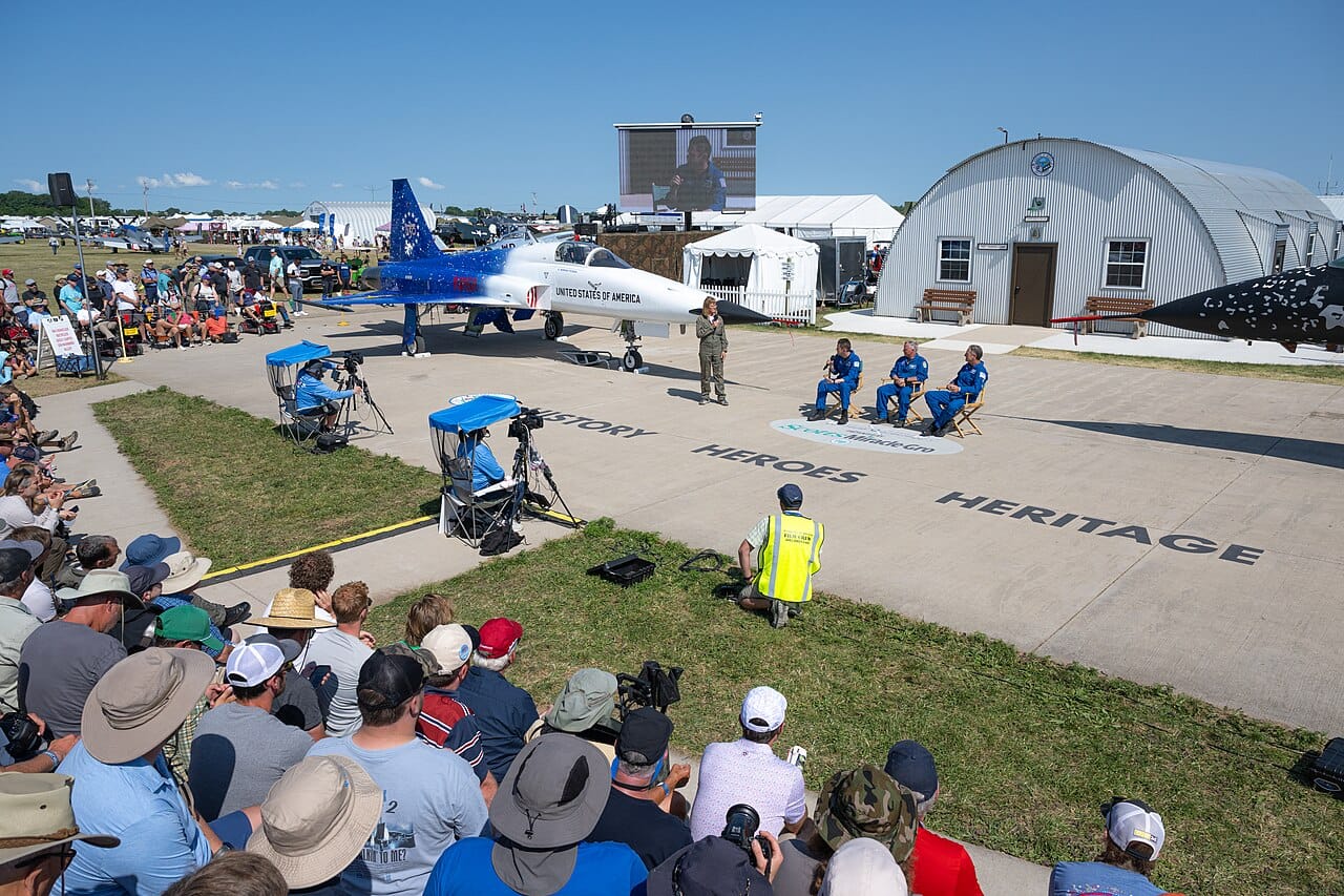 A large crowd at a Warbirds in Review presentation at EAA AirVenture Oshkosh 2026