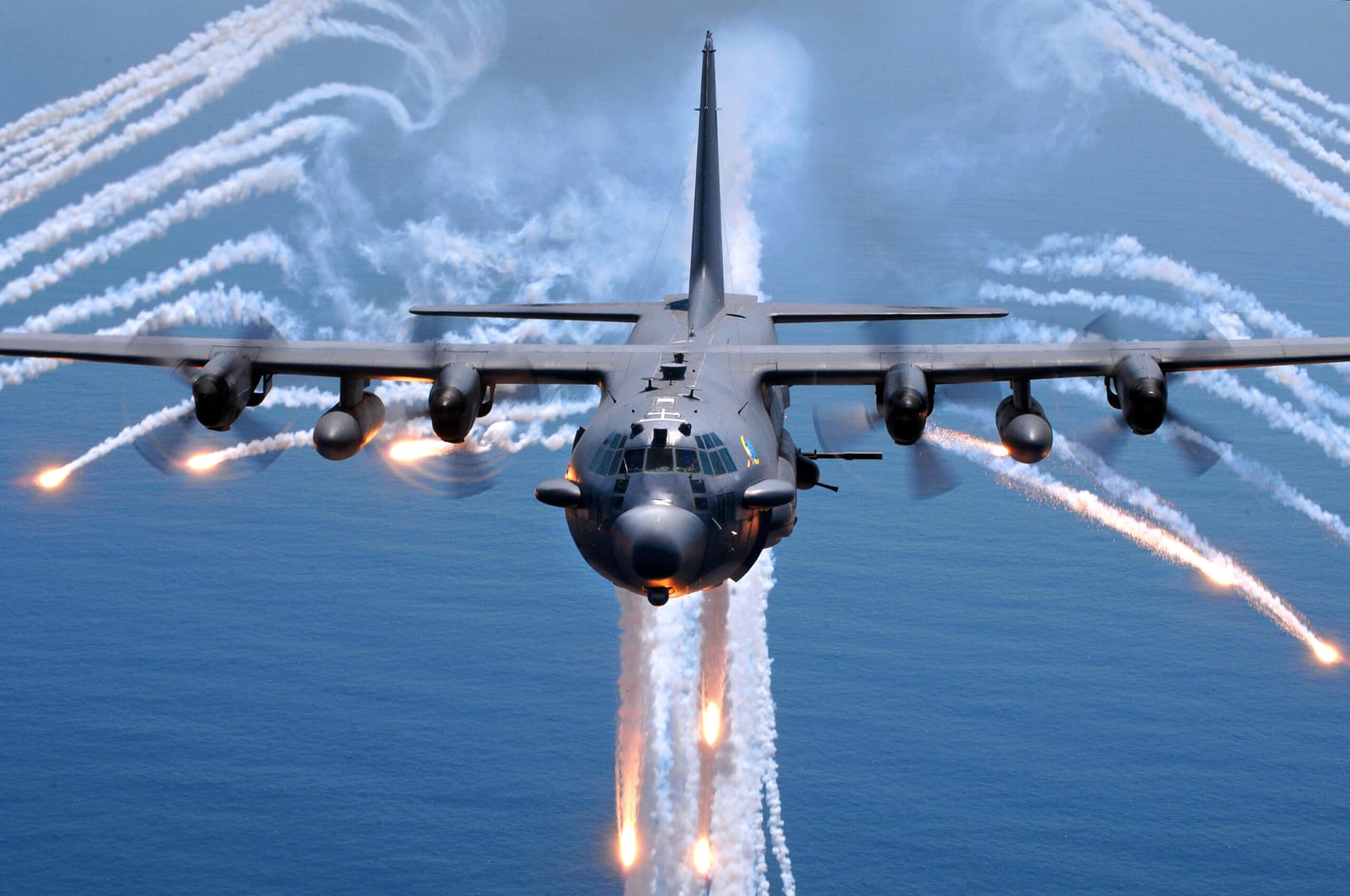 Ein AC-130H Spectre-Kampfhubschrauber wirft Täuschkörper im Engelsmuster ab.