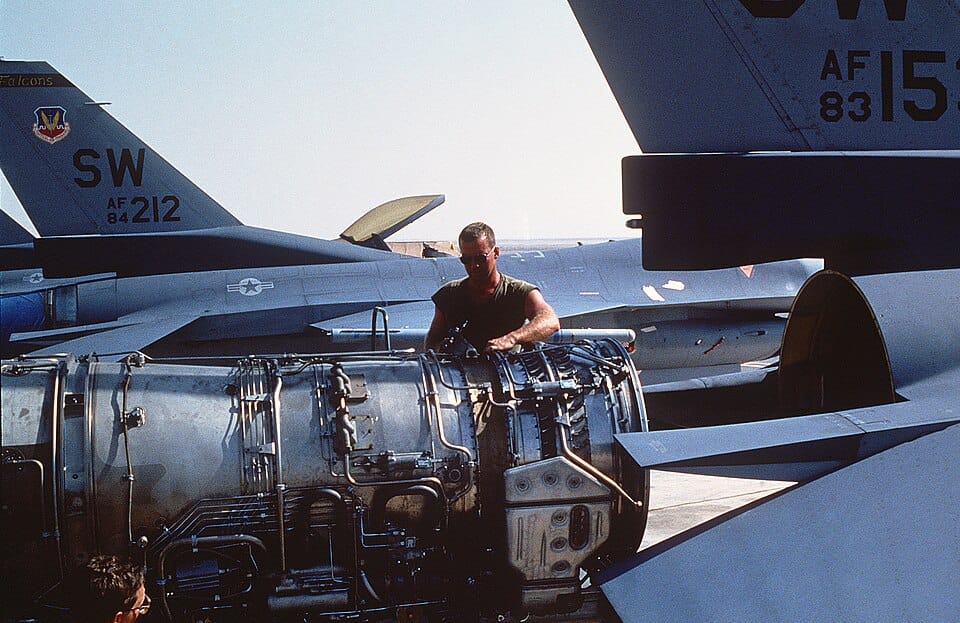 Aircraft mechanic working on jet engine during maintenance