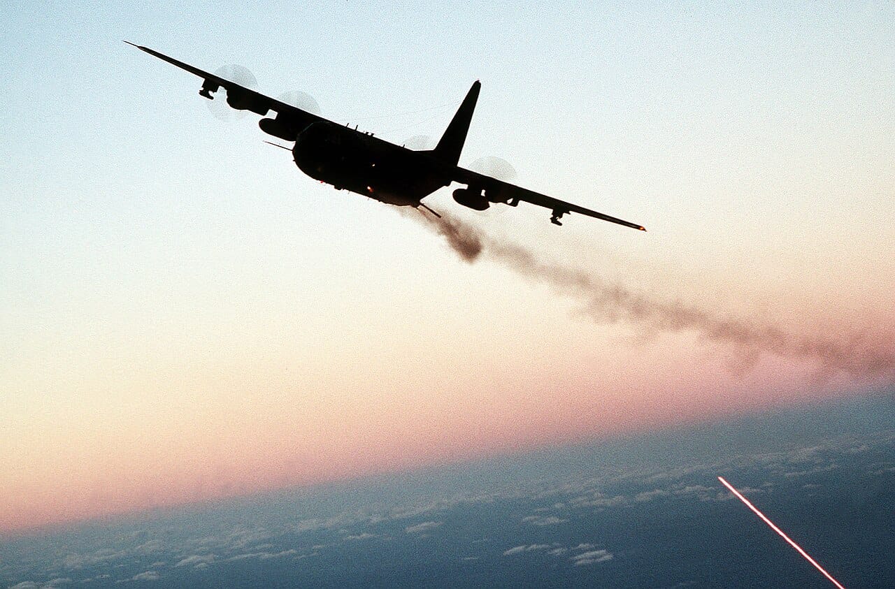 Un aereo da attacco AC-130 spara con le sue armi in bordata durante una missione notturna.