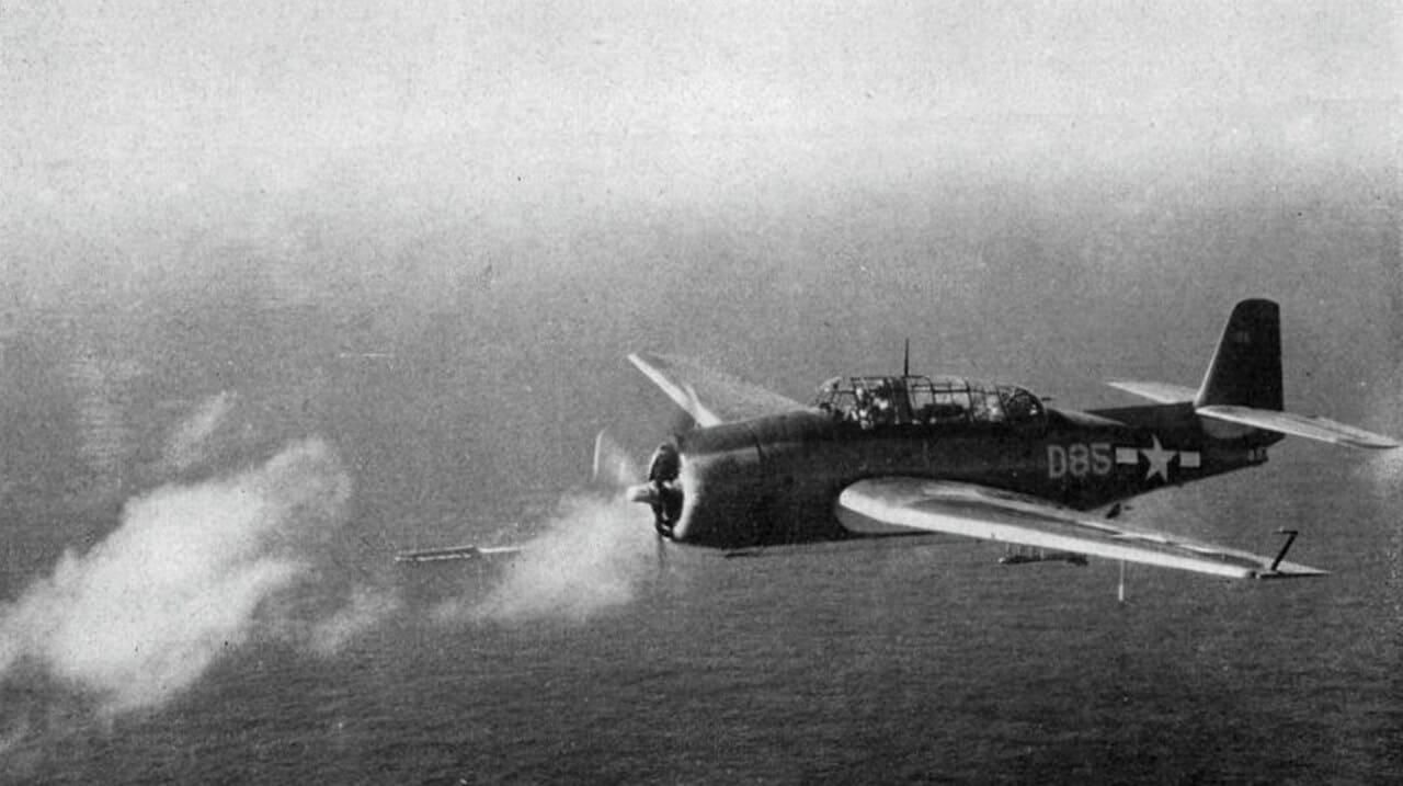 Eine Grumman TBF Avenger der US Navy über einem Geleitflugzeugträger im Jahr 1944