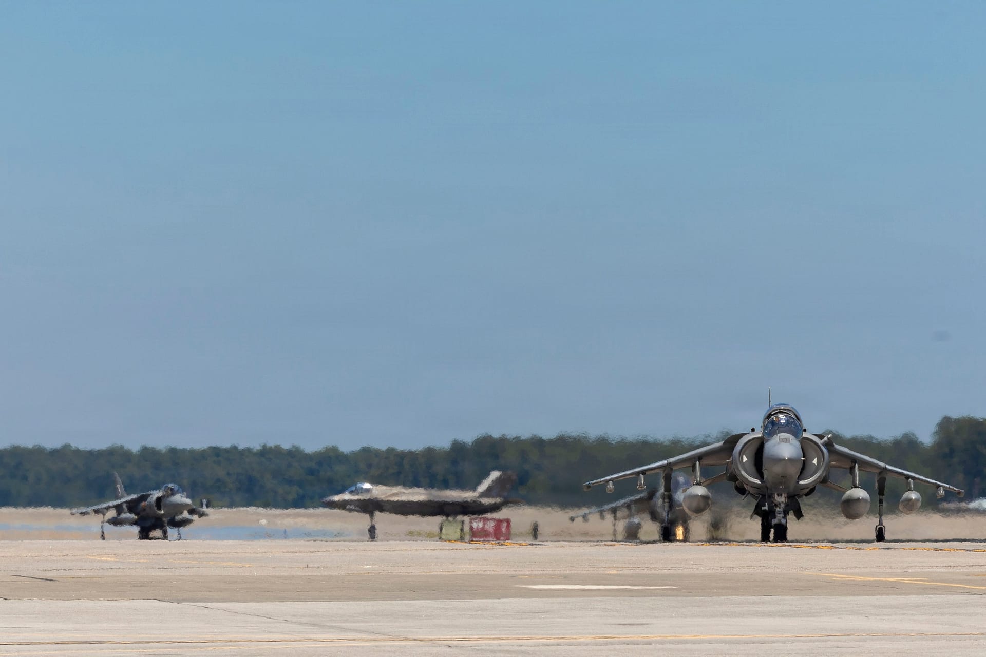A USMC F-35B of VMFA-231 taxis behind AV-8B Harriers at MCAS Cherry Point