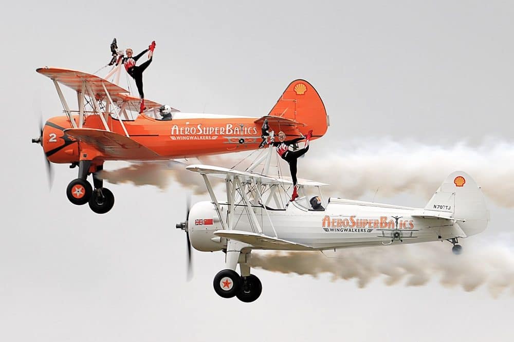 Two AeroSuperBatics wingwalkers perform on Boeing Stearman biplanes