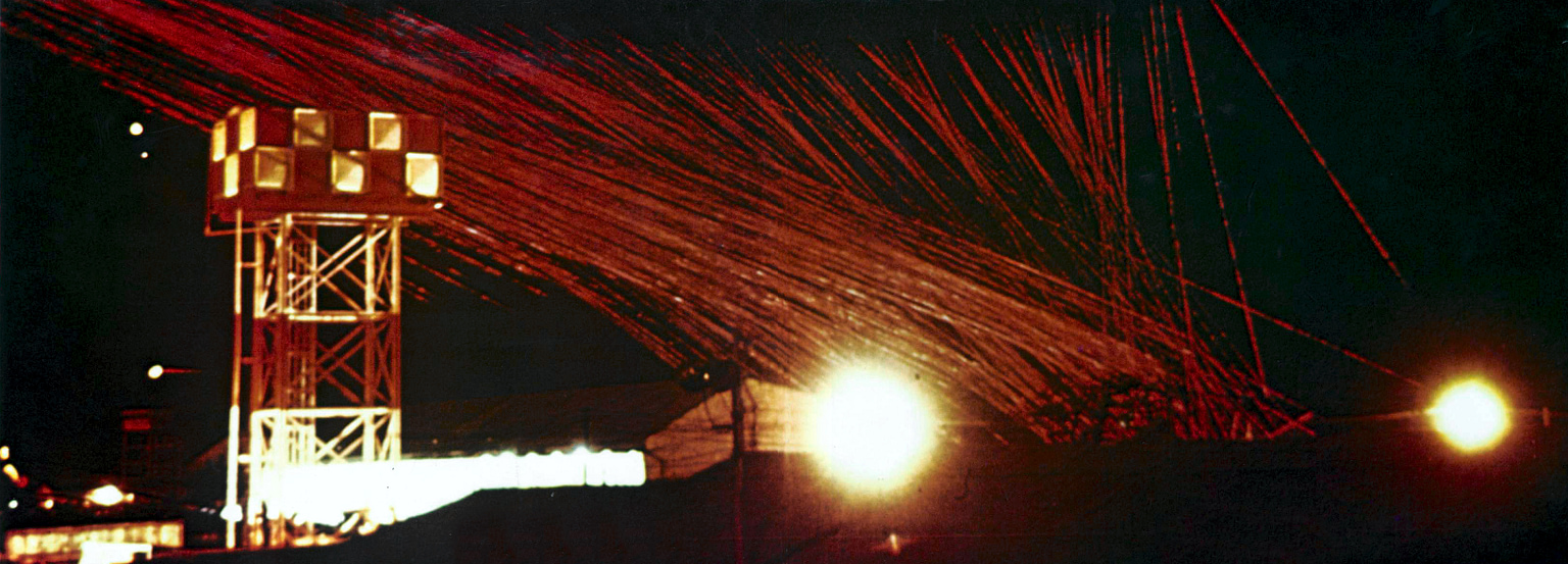 Douglas AC-47 Spooky gunship firing minigun tracers at night over South Vietnam