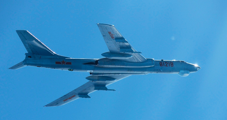 A Xian H-6 carrying underwing missiles, photographed over the sea on a maritime patrol.