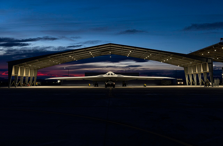 B-21 Raider inside a sunlit hangar at Edwards Air Force Base