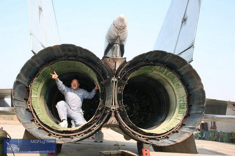 A person sitting inside the twin engine nozzles of a MiG-25