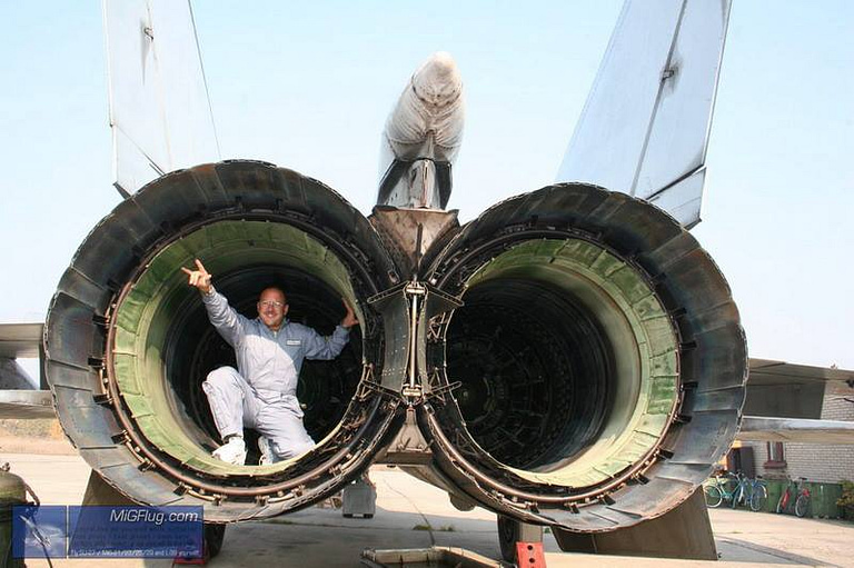 A person sitting inside the twin engine nozzles of a MiG-25