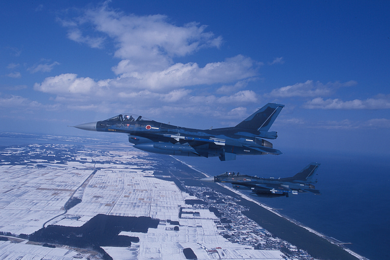 An F-2 banks over the Japanese coastline it was designed to defend.