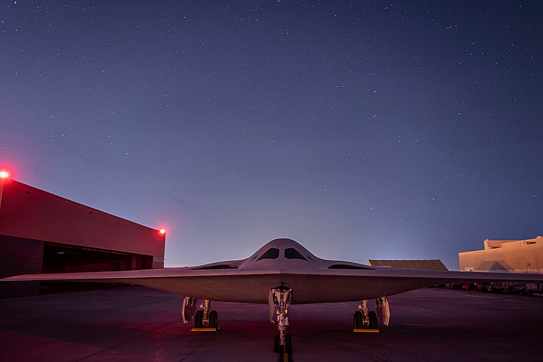 B-21 Raider silhouetted under red light at its December 2022 rollout in Palmdale