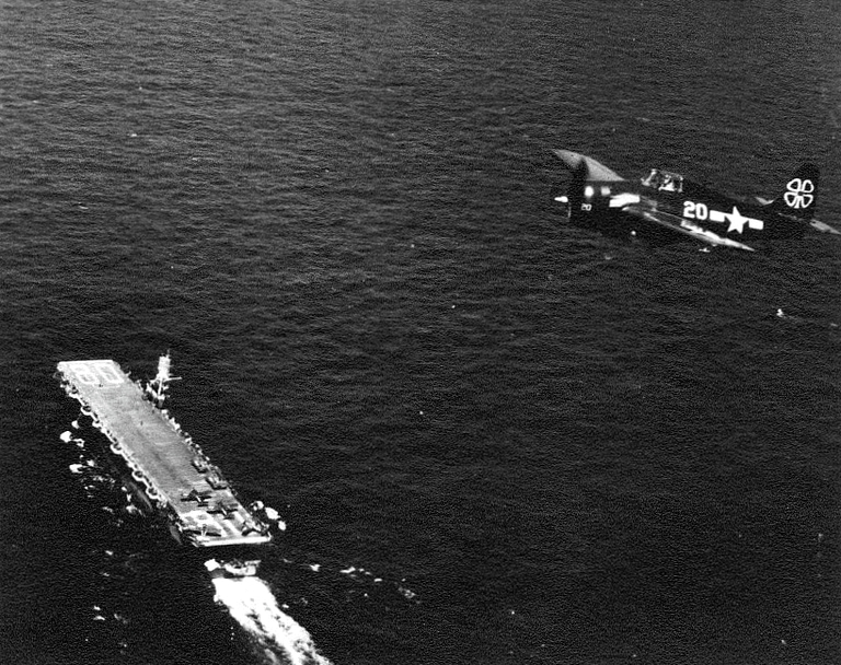 A GM-built FM-2 Wilder Wildcat over the escort carrier USS Petrof Bay, 1945.