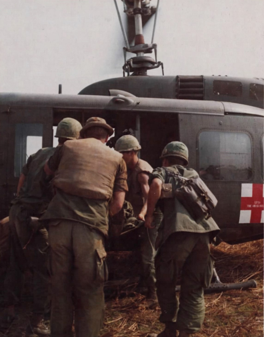 A wounded soldier is loaded onto a 57th Medical Detachment Dustoff UH-1D medevac.