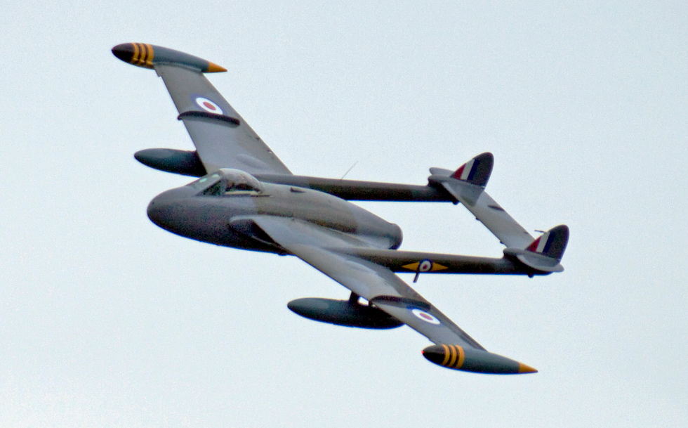 A de Havilland Venom banking in flight the twin-boom silhouette that marked de Havillands first jet generation.
