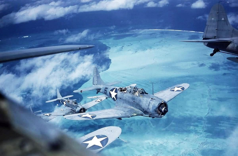 A Marine SBD-3 of VMSB-241 in flight over Midway atoll, around 1942.
