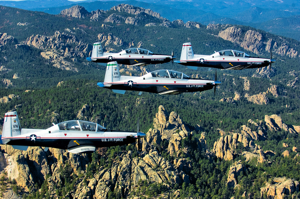 A four-ship formation of U.S. Air Force T-6A Texan IIs over Vance Air Force Base.