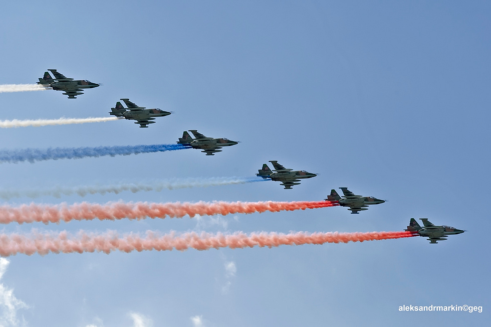 A formation of Su-25s in flight, showing the types straight wings and twin engines.