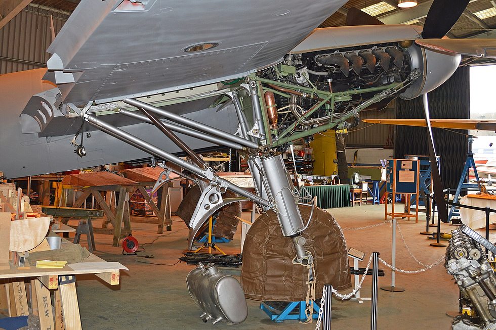 A Mosquito FB.VI under restoration, its wooden structure and Merlin exposed.