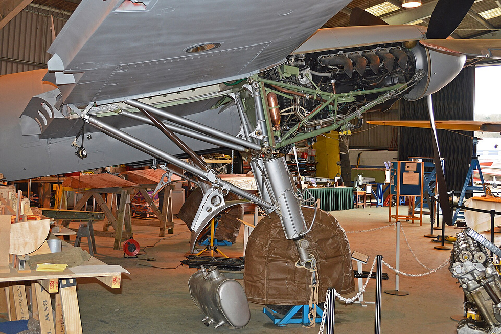 A Mosquito FB.VI under restoration, its wooden structure and Merlin exposed.