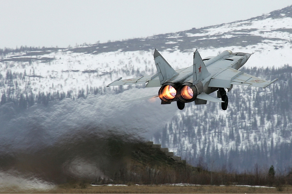 MiG-25RB Foxbat taking off on afterburner over snowy mountains