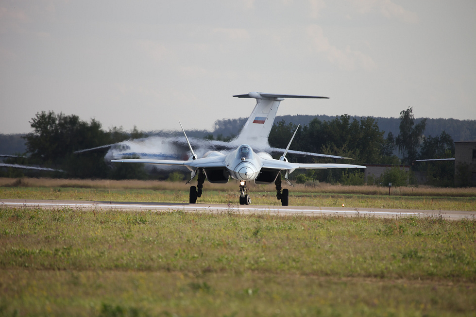A front view of the Su-57, showing its faceted forward fuselage and widely spaced engines.