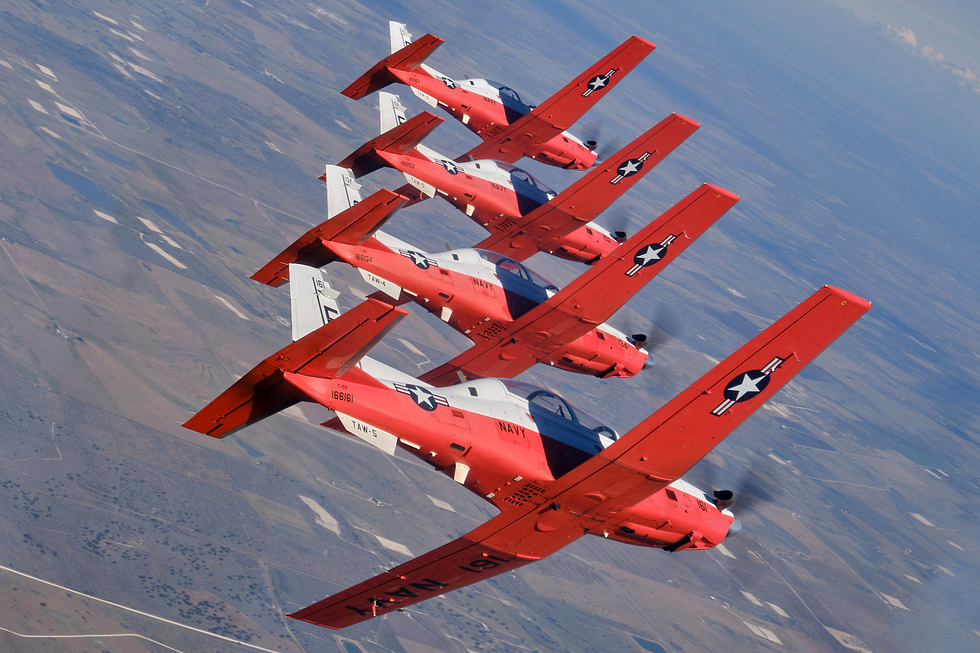 U.S. Navy T-6B Texan IIs in a four-ship formation over a military operations area in southern Texas.