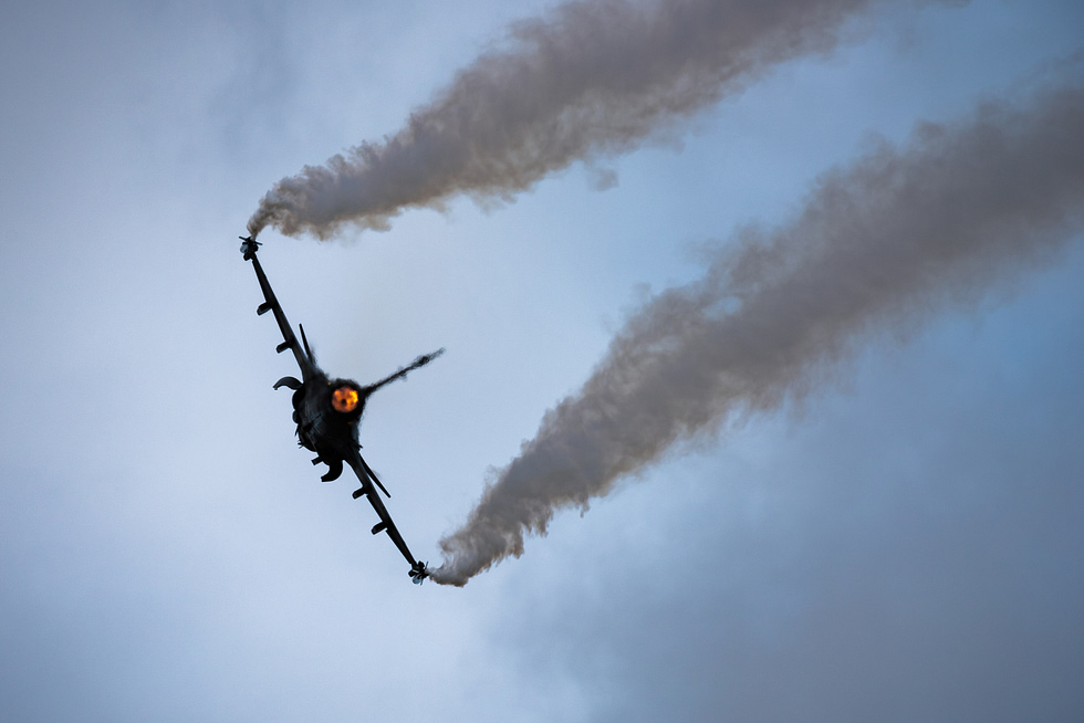 A Swedish JAS 39C in dramatic silhouette at RIAT 2023 the canard-delta planform in full.