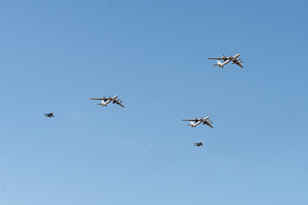 A Su-33 banks overhead in a Navy Day flypast, its planform and hardpoints in view.