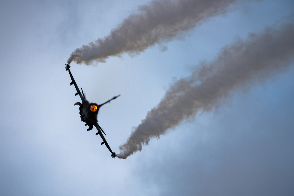 A Swedish JAS 39C in dramatic silhouette at RIAT 2023 the canard-delta planform in full.