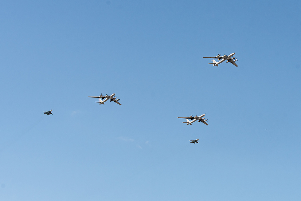 A Su-33 banks overhead in a Navy Day flypast, its planform and hardpoints in view.