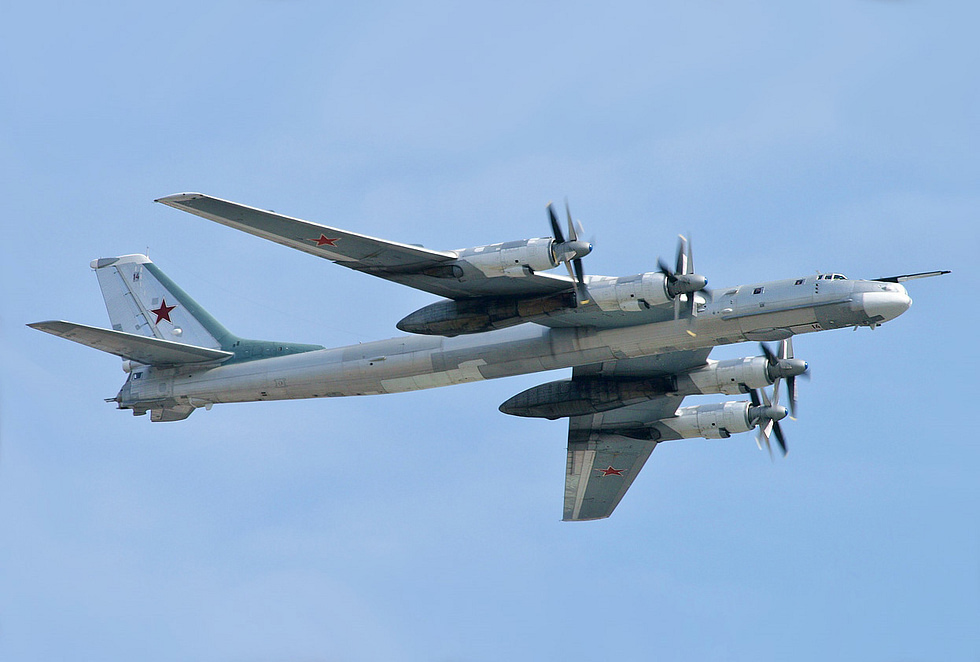 A Tu-95 banking in flight swept wings and four contra-rotating turboprops.