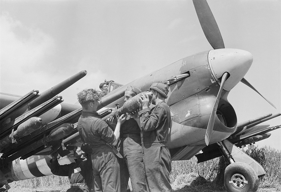 Ground crews load 3-inch RP-3 rockets onto a Typhoon IB of No. 247 Squadron at B2-Bazenville, Normandy, 15 June 1944.