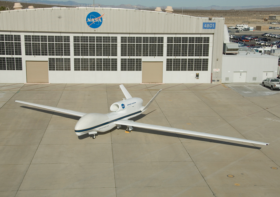 A NASA Global Hawk outside its hangar, its long, glider-like wing on full display.