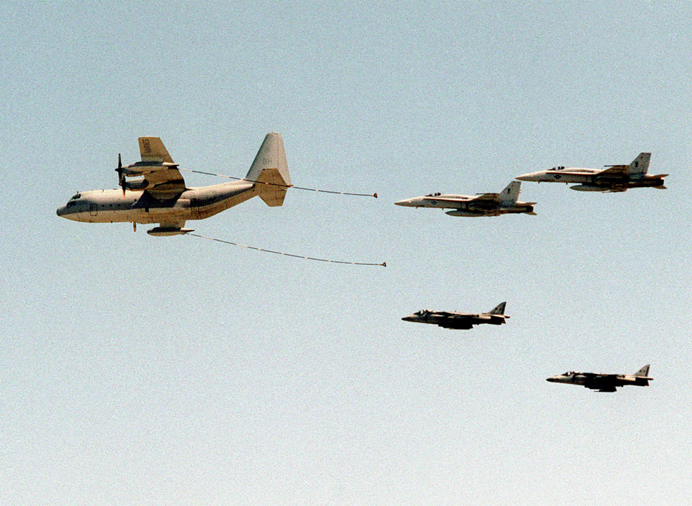 A KC-130 Hercules tanker refuels Marine Corps fighters in flight, showing the aircrafts aerial-refuelling role.