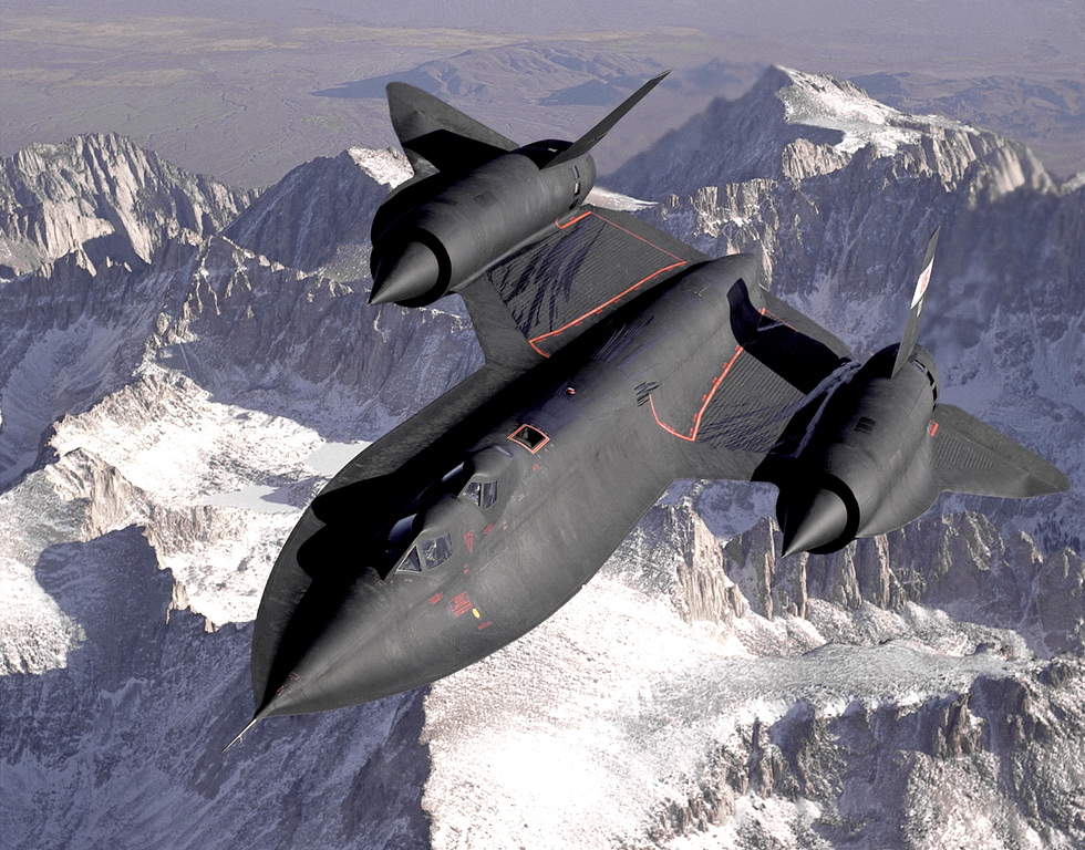 SR-71 banking in flight over snow-covered mountains