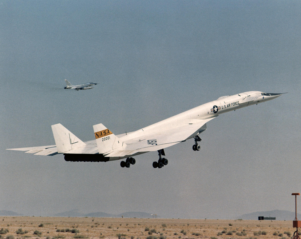 AV-1 lifting off on a research flight with a chase aircraft alongside.