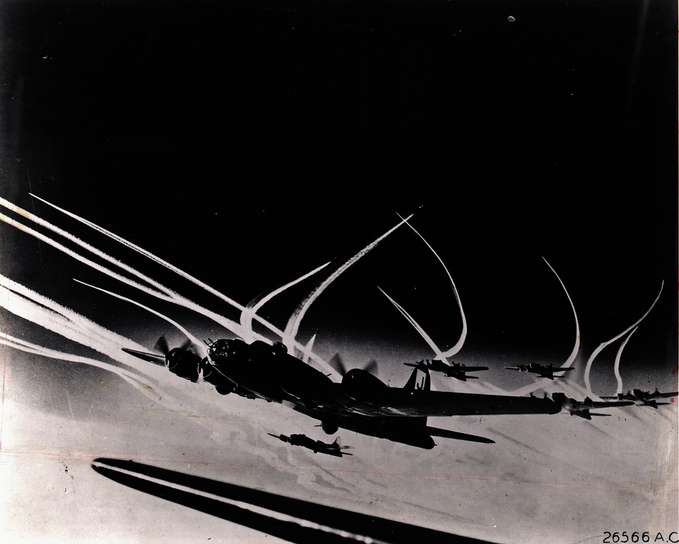 B-17s in a tight formation, contrails streaming the combat box that pooled their defensive fire.