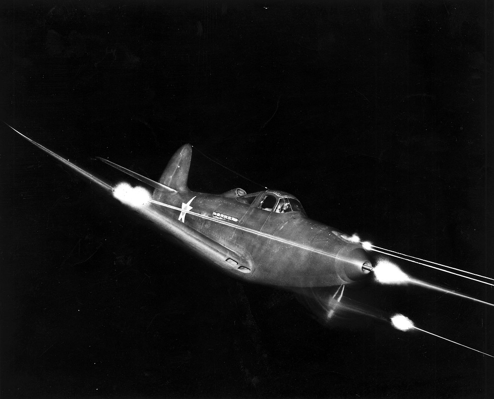 A P-39 firing all weapons at night the 37mm cannon and machine guns lighting the dark.