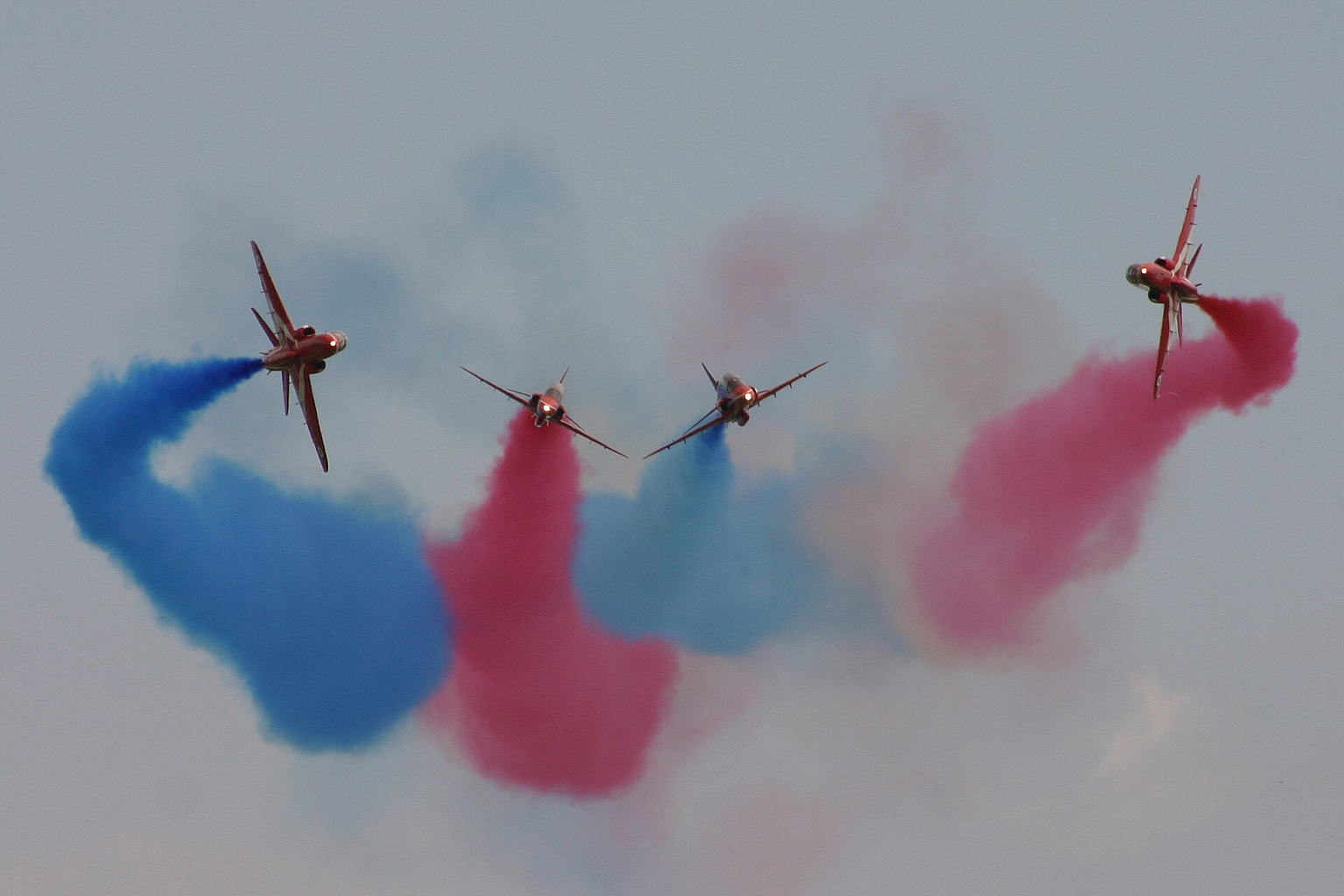 BAE Hawk jets of the Red Arrows crossing with display smoke in flight