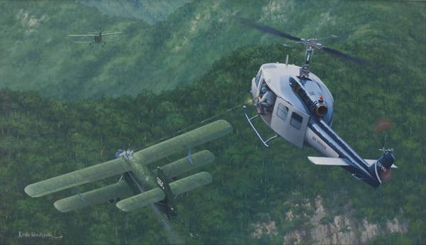 A painting of the Air America Huey engaging Vietnamese An-2 Colt biplanes over Laos, January 1968