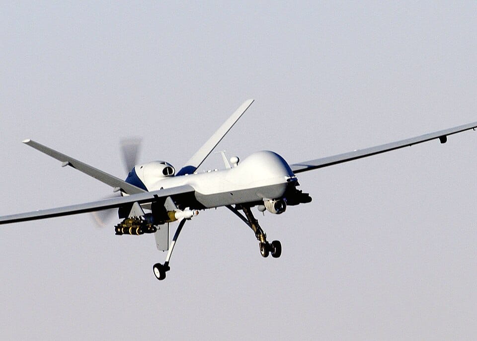 MQ-9 Reaper drone in flight over terrain